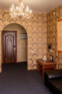 鄂木斯克Malibu Hotel的一间设有吊灯、门和桌子的房间