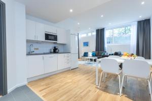 松德比贝里ApartDirect Sundbyberg的厨房以及带桌椅的起居室。