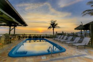 弗洛里亚诺波利斯科斯塔诺特英国酒店的一个带椅子的游泳池,享有日落美景