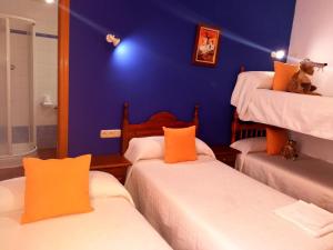 坎波德克里普塔纳Hostal Restaurante Ego's的一间设有三张床和蓝色墙壁的房间