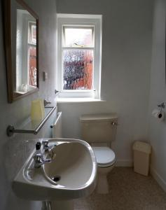 布莱克浦海菲尔德私人酒店 的一间带水槽和卫生间的浴室以及窗户。