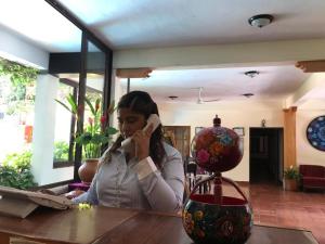 恰帕德科尔索Yaxché的坐在一张桌子旁的一位女士,在手机上讲话