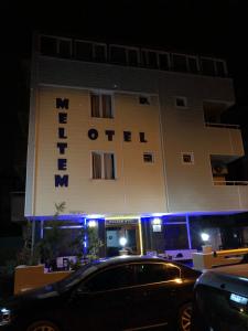 安塔利亚Meltem Otel的晚上停在酒店门前的汽车