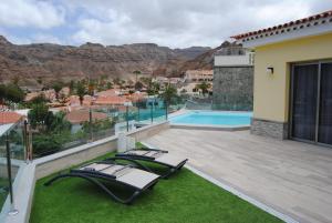 莫甘Villa Sunset Tauro的一个带两把躺椅的庭院和一个游泳池