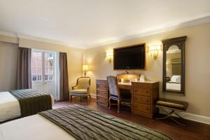 新奥尔良圣玛丽酒店的酒店客房带一张床、一张书桌和一面镜子