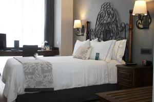 墨西哥城Zocalo Central & Rooftop Mexico City的一间卧室配有一张白色大床和黑色床头板