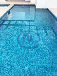 佩尼亚斯科港Casita de Moana的蓝色的游泳池,水中有一个标志