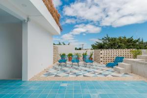 坎昆Studios Downtown Cancun的天井配有蓝色椅子,铺有瓷砖地板。