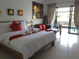 高兰Arthaya Villas - SHA Extra Plus的卧室配有带红色枕头的大型白色床