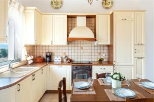古卡斯特隆Villa Aiolos的厨房配有白色橱柜、桌子和水槽。