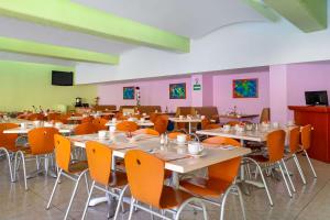 韦拉克鲁斯韦拉克鲁斯舒适酒店的用餐室配有桌椅和粉红色的墙壁