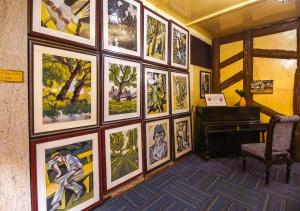 Kurseong科克兰广场酒店的一间拥有画墙和钢琴的房间