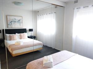 墨尔本北墨尔本休闲度假酒店的一间卧室配有两张床和镜子