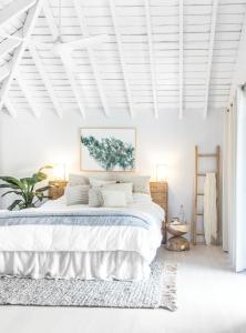 长岛Elysian Luxury Eco Island Retreat的白色卧室设有一张白色墙壁的大床