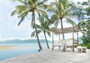 长岛Elysian Luxury Eco Island Retreat的棕榈树和海洋海滩上的吊床