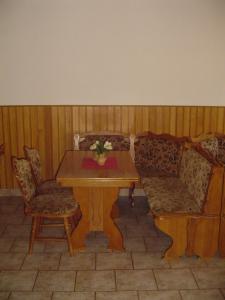弗尔赫拉比Pension Baron的一张带两把椅子的木桌和一张带鲜花的桌子