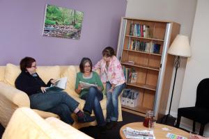 阿尼克Alnwick Youth Hostel的三个女人坐在客厅的沙发上