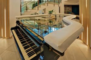 金沙MiRaBelle Hotel - Half Board Plus & All Inclusive的玻璃桌和钢琴