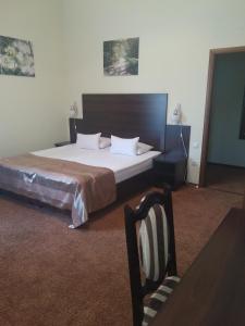 敖德萨12个月迷你酒​​店的一间卧室配有一张大床和一把椅子