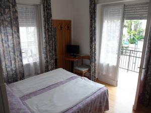 加尔达湖滨里亚托酒店的一间卧室设有一张床和一个滑动玻璃门