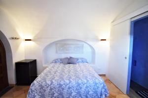 潘泰莱里亚DAMMUSI IL CARRUBO的一间卧室配有一张带蓝色棉被的床
