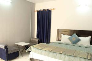 新德里Comfort Point Bed & Breakfast的一间卧室配有一张床、一把椅子和一张桌子