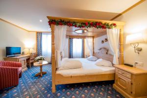迈林根阿尔卑巴赫酒店的一间卧室配有带圣诞装饰的天蓬床。