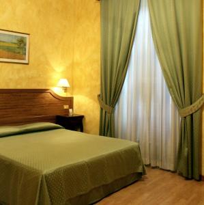 罗马费欧瑞酒店的一间卧室配有床和带窗帘的窗户