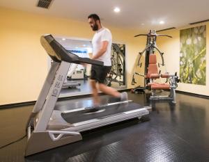 伍珀塔尔Flemings Hotel Wuppertal-Central的跑在健身房跑步机上的人