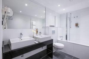 伍珀塔尔Flemings Hotel Wuppertal-Central的白色的浴室设有2个盥洗盆和1个卫生间。