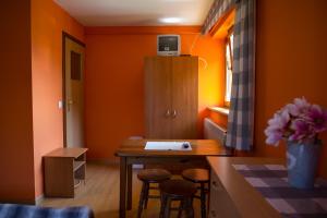 乔尔什滕Noclegi U Wolskiego的一间拥有橙色墙壁、桌子和凳子的房间