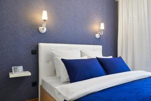 明斯克PaulMarie Apartments on Mayakovskogo 35的一间卧室配有一张带蓝色和白色枕头的床
