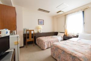 铃鹿市Suzuka Royal Hotel的酒店客房配有两张床和一张书桌