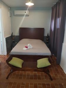 法兰西堡La DEPENDANCE CREOLE的一间卧室配有一张带两个绿色枕头的床