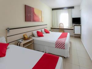 圣若泽杜斯坎普斯Polo Hotel的酒店客房 - 带两张带红色枕头的床