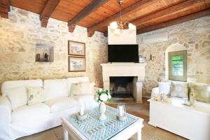 卡米拉日Villa Pasiphae的客厅配有白色沙发和壁炉