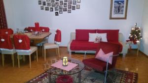 菲根Chalet Tyrol的客厅配有红色的沙发和桌子