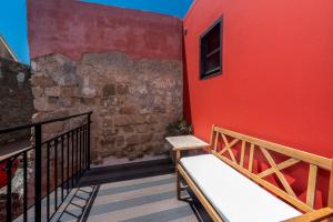 罗德镇佐科斯塔别墅酒店的阳台的红色建筑,长凳