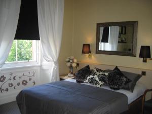 爱丁堡提斯特尔酒店的一间卧室配有带枕头和镜子的床