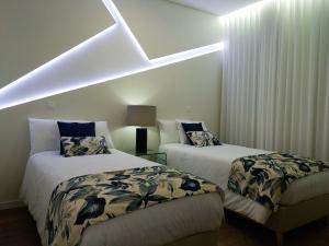 蓬塔德尔加达INNature的配有倾斜天花板的客房内的两张床