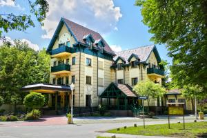 帕利克Hotel & Spa PALIĆ RESORT的黑色屋顶的大型黄色建筑