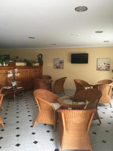 桑亨霍拜萨斯酒店的一间设有藤椅、桌子和电视的等候室