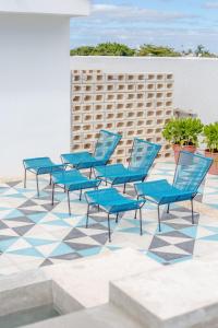 坎昆Studios Downtown Cancun的瓷砖庭院里一组蓝色椅子