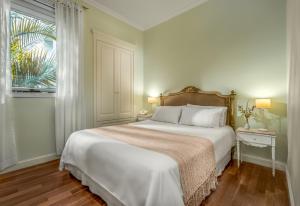 布宜诺斯艾利斯菲尼斯特拉248号酒店的卧室设有一张白色大床和一扇窗户。