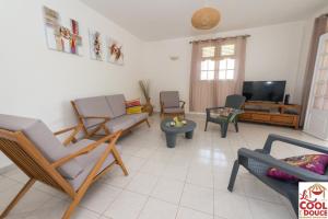 哥西尔Kouleur Karayib的客厅配有椅子和平面电视