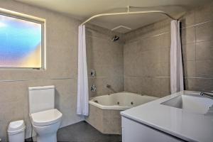 皇后镇亚历克西斯汽车旅馆&公寓的浴室配有卫生间、浴缸和水槽。