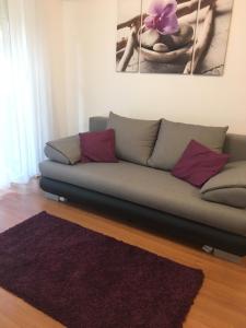 德布勒森ROSE Apartman的客厅内的一张沙发,铺有紫色地毯