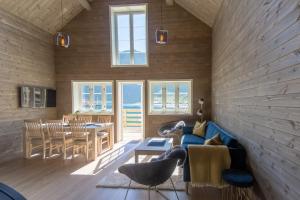 雷讷Reine seaview cabin的客厅配有蓝色的沙发和桌子