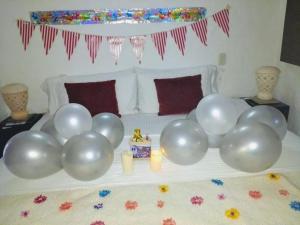 巴里查拉巴里查拉洛马酒店 的床上的一组气球,有蜡烛