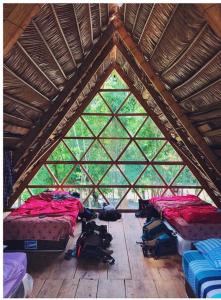 兰金Pachamaya River Hostel的木天花板上设有三张床的房间